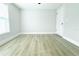 An empty bedroom featuring wood-look flooring, window and white painted walls at 7909 Woodgrove Cir, Tampa, FL 33615