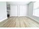 Bright bedroom featuring newly installed, light-colored laminate flooring and generous closet space at 7909 Woodgrove Cir, Tampa, FL 33615