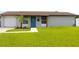 Charming single-story home boasts a well-manicured lawn and a vibrant blue front door at 7909 Woodgrove Cir, Tampa, FL 33615