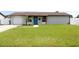 Charming single-story home boasts a well-manicured lawn and a vibrant blue front door at 7909 Woodgrove Cir, Tampa, FL 33615