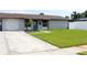 Beautiful home featuring fresh landscaping, vibrant lawn, and a driveway leading to the attached garage at 7909 Woodgrove Cir, Tampa, FL 33615