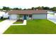 Picture of a freshly landscaped front yard with a well-maintained lawn and light grey single story house at 7909 Woodgrove Cir, Tampa, FL 33615