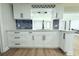 Kitchen featuring white cabinetry, marble backsplash, and stainless faucet at 7909 Woodgrove Cir, Tampa, FL 33615