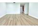 A spacious, light-filled room featuring modern laminate flooring and fresh, neutral paint at 7909 Woodgrove Cir, Tampa, FL 33615