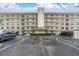 Exterior shot of a multi-story condo building featuring a well-maintained parking area and landscaping at 8198 Terrace Garden Dr # 511, St Petersburg, FL 33709