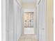 Hallway featuring tile floors, linen closets and bathroom access with palm tree shower curtain at 8198 Terrace Garden Dr # 511, St Petersburg, FL 33709