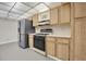 Kitchen with stainless steel refrigerator and oak cabinets, complete with gas range at 8198 Terrace Garden Dr # 511, St Petersburg, FL 33709