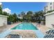 Community swimming pool with lounge chairs, lush greenery, and clear blue water for relaxation and enjoyment at 8198 Terrace Garden Dr # 511, St Petersburg, FL 33709