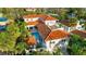 A stunning aerial view of this luxurious home featuring a red tile roof, pool, and lush landscaping at 831 Mandalay Ave, Clearwater, FL 33767