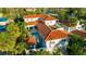 Stunning aerial view of a Mediterranean-style home with a terracotta roof, pool, and lush tropical landscaping at 831 Mandalay Ave, Clearwater, FL 33767