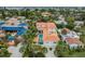 Aerial view showcasing the home's pool and rooftop patio with palm tree landscaping at 831 Mandalay Ave, Clearwater, FL 33767