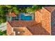 Aerial view of the orange tiled roof, backyard swimming pool and lush greenery at 831 Mandalay Ave, Clearwater, FL 33767