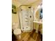 Clean bathroom featuring a corner shower, pedestal sink, and toilet with vinyl wood look flooring at 831 Mandalay Ave, Clearwater, FL 33767