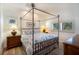 Bright bedroom featuring a four-poster bed with tropical-themed bedding, complemented by wood-look floors and natural light at 831 Mandalay Ave, Clearwater, FL 33767