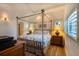 Comfortable bedroom features a four-poster bed with tropical bedding, wood-look floors, and recessed lighting at 831 Mandalay Ave, Clearwater, FL 33767