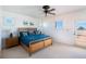 Bright bedroom with a ceiling fan, a queen bed, shuttered windows, and an access door to a deck at 831 Mandalay Ave, Clearwater, FL 33767