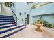 Courtyard with blue walls, fountain, and stairs to an upper level with wrought iron gate at 831 Mandalay Ave, Clearwater, FL 33767