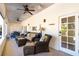 Covered patio features wicker seating, ceiling fans, and outdoor access to the yard at 831 Mandalay Ave, Clearwater, FL 33767