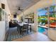 Large covered patio with BBQ grill, table, comfortable seating and view of pool and landscaping at 831 Mandalay Ave, Clearwater, FL 33767