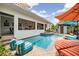 Outdoor pool with brick patio, complete with lounge chairs and umbrellas at 831 Mandalay Ave, Clearwater, FL 33767