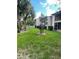 Scenic backyard showcasing a lush green lawn, mature palm trees, and attractive condo buildings at 8636 Tahoe Ct # 13, Tampa, FL 33614