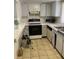 Compact kitchen featuring white cabinets and standard appliances at 8636 Tahoe Ct # 13, Tampa, FL 33614
