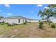 Spacious backyard with a mix of grass, small trees, and a white fence offering privacy at 9429 Northcliffe Blvd, Spring Hill, FL 34606