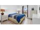 Bedroom with a plush blue bed, a window, and matching white nightstands at 9429 Northcliffe Blvd, Spring Hill, FL 34606