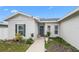 Inviting front porch with a blue front door, complemented by potted plants and updated landscaping features at 9429 Northcliffe Blvd, Spring Hill, FL 34606