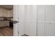 Hallway view of white shutter closet doors leading to kitchen with granite countertops and white cabinets at 9429 Northcliffe Blvd, Spring Hill, FL 34606