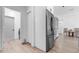 Open-concept kitchen featuring stainless steel refrigerator and adjacent laundry room at 9429 Northcliffe Blvd, Spring Hill, FL 34606