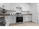 Modern kitchen featuring stainless steel oven, granite countertops, and white cabinets at 9429 Northcliffe Blvd, Spring Hill, FL 34606