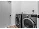 Modern laundry room featuring front-load washer and dryer, with convenient access from the kitchen at 9429 Northcliffe Blvd, Spring Hill, FL 34606