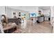 Open-concept living room with modern furniture, hardwood flooring, and natural light flowing into the adjacent kitchen at 9429 Northcliffe Blvd, Spring Hill, FL 34606