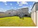 Spacious backyard with green lawn, patio furniture, and a privacy fence, ideal for outdoor living and entertaining at 9440 Lemon Drop Loop, Sun City Center, FL 33573