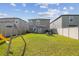 Large, fenced backyard with a well-maintained lawn, a swing set, patio furniture, and a door to the house at 9440 Lemon Drop Loop, Sun City Center, FL 33573