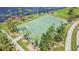 Aerial view of a community basketball court next to a pond, surrounded by lush landscaping and trees at 9440 Lemon Drop Loop, Sun City Center, FL 33573