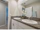 Bright bathroom featuring double sinks, granite countertops, white cabinets and modern fixtures at 9440 Lemon Drop Loop, Sun City Center, FL 33573