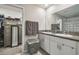Double vanity in bathroom with granite countertops and a walk-in closet at 9440 Lemon Drop Loop, Sun City Center, FL 33573