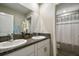 Bright bathroom featuring double sinks, granite countertops, and a shower with curtain at 9440 Lemon Drop Loop, Sun City Center, FL 33573