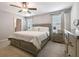 Neutral toned bedroom with white bedding, two windows, and light wood furniture at 9440 Lemon Drop Loop, Sun City Center, FL 33573