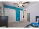 This cozy bedroom features a ceiling fan, carpet flooring, and blue accent wall at 9440 Lemon Drop Loop, Sun City Center, FL 33573