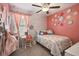 Pink bedroom with a rainbow theme, desk, and white furniture at 9440 Lemon Drop Loop, Sun City Center, FL 33573