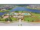 Aerial view of community amenities including pool, clubhouse, and lush landscaping, all near a scenic lake at 9440 Lemon Drop Loop, Sun City Center, FL 33573