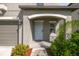 Inviting front entrance with a covered porch, manicured landscaping, and a gray exterior at 9440 Lemon Drop Loop, Sun City Center, FL 33573