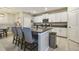 Modern kitchen features white cabinets, granite counters, stainless steel appliances, and island with barstool seating at 9440 Lemon Drop Loop, Sun City Center, FL 33573