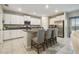 Spacious kitchen boasts white cabinets, stainless steel appliances, granite counters, and an island with seating at 9440 Lemon Drop Loop, Sun City Center, FL 33573