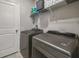 Functional laundry room with a side-by-side washer and dryer, overhead shelving, and a utility closet at 9440 Lemon Drop Loop, Sun City Center, FL 33573
