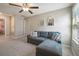 Comfortable living area with plush sectional sofa, ceiling fan, natural light from window, and neutral decor at 9440 Lemon Drop Loop, Sun City Center, FL 33573