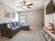 Inviting living room features a cozy sectional, ceiling fan, large windows, and a mounted television at 9440 Lemon Drop Loop, Sun City Center, FL 33573